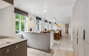 a kitchen with white cabinets and a dining room at Solhj in Sønder Felding