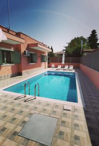 a swimming pool in front of a house at Elpida Suites in Nea Irakleia