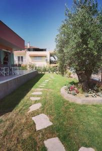 a garden with stepping stones in the grass at Elpida Suites in Nea Iraklia