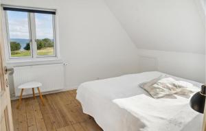 Habitación blanca con cama y ventana en Awesome Home In Bandholm With House Sea View en Bandholm