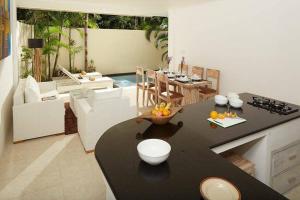 a kitchen and living room with a black counter top at Yoga Villa in Seminyak