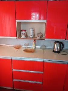a red kitchen with red cabinets and a tea kettle at MANGO Guesthouse in Sighnaghi