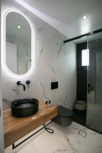 bagno con lavandino nero e specchio di Naxos White Concept a Naxos Chora