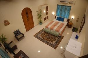 Schlafzimmer mit einem Bett und einer Holztür in der Unterkunft Cascara Beach Resort in Varkala
