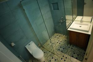 a bathroom with a shower and a toilet and a sink at Cascara Beach Resort in Varkala