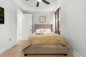 een slaapkamer met een bed en een plafondventilator bij Villa De Briley in Houston