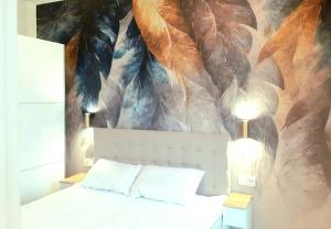 um quarto com uma cama com um mural de penas em Apartament Tropikalny prywatny taras na dachu z widokiem na morze em Sianozety