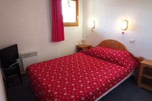 - une chambre avec une couette rouge sur un lit dans l'établissement Les Balcons du Soleil Appt303 à100m pistes 2 chambres parking couvert WIFI, à Orcières 33 autres photos