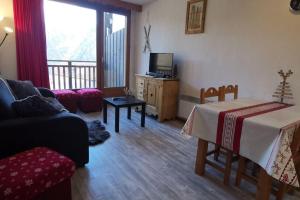 un salon avec un canapé et une télévision dans l'établissement Les Balcons du Soleil Appt303 à100m pistes 2 chambres parking couvert WIFI, à Orcières