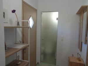 uma casa de banho com um chuveiro e uma porta de vidro em La casetta em Roda