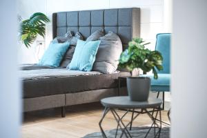 Un dormitorio con una cama con almohadas azules y una mesa. en Das CRAZY MONKEY LOFT mit 100qm & Summerlounge en Stuttgart