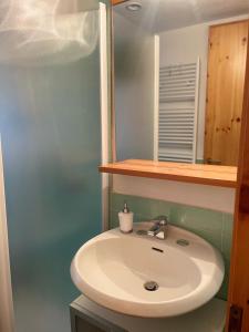 bagno con lavandino bianco e specchio di Il Rifugio di Marcella a Challand Saint Anselme