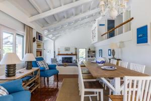 a dining room and living room with a table and chairs at Villa Pelago in Skopelos Town