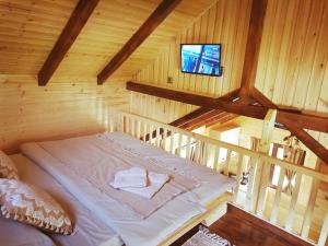 a room with a bed in a wooden cabin at Cazare la Vama Buzăului - Căsuța Festung in Vama Buzăului