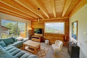 a living room with a couch and a tv at Magnifique Chalet neuf 8 pers, 800 m télécabine Princesse Megeve in Combloux