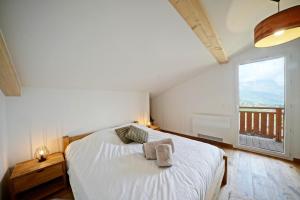 sypialnia z białym łóżkiem i dużym oknem w obiekcie Magnifique Chalet neuf 8 pers, 800 m télécabine Princesse Megeve w mieście Combloux