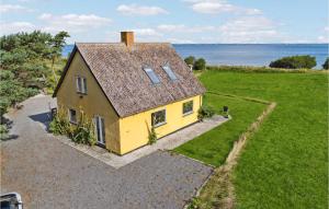una vista aérea de una casa amarilla con el océano en el fondo en Awesome Home In Bandholm With House Sea View en Bandholm