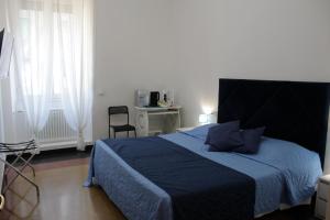- une chambre avec un lit et une couette bleue dans l'établissement LA LANTERNA DI ANGELO, à Gênes