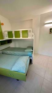 a room with two beds with green and white at Appartamento all ‘Argentario Porto Santostefano Gr in Porto Santo Stefano