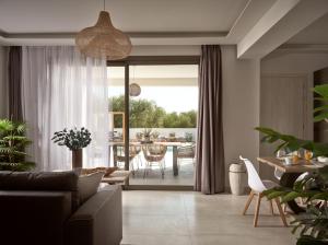 a living room with a couch and a table at Kapodistria Luxury Villas - 3-Bedroom Villas with Private Pool, by ZanteWize in Planos