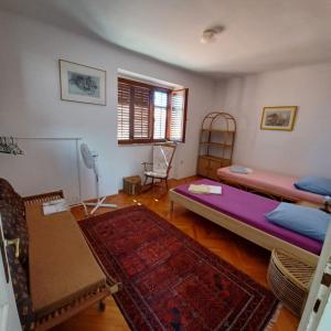 a living room with two beds and a table at Old Town Arbia in Rab