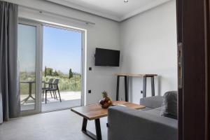 een woonkamer met een bank en een glazen schuifdeur bij Robin's in Lefkada
