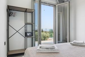 a bedroom with a bed and a large glass door at Robin's in Lefkada