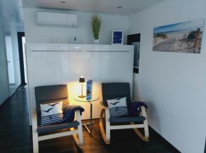 twee stoelen en een tafel met een lamp in een kamer bij Hausboot Leukermeer Well in Well