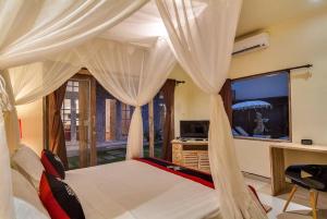 Schlafzimmer mit einem Bett mit Vorhängen und einem Schreibtisch in der Unterkunft Selog Villa 2 in Seminyak