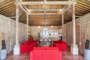 ein Wohnzimmer mit roten Sofas und einem Tisch in der Unterkunft Selog Villa 2 in Seminyak