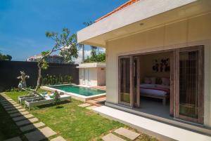 ein Haus mit einem Bett und einem Pool in der Unterkunft Selog Villa 2 in Seminyak