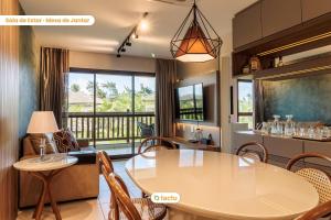 a kitchen and dining room with a table and chairs at Bangalô frente jardim no VG Sun Cumbuco por Tactu in Cumbuco