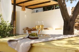 a table with two glasses of wine and a bowl of grapes at Syrolia village in Kini