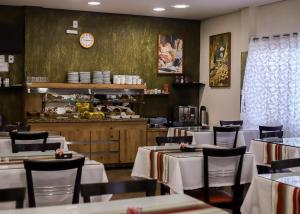 Arpini Hotel في ريو غراندي: غرفة طعام مع طاولات وكراسي وكاونتر