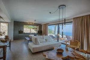 a living room with a white couch and a large window at Armante Supreme Villas-Villa Nicole in Fternón