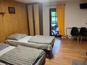 a room with three beds and a door with a window at Zajazd Jurajski in Podlesice