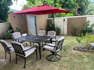 a table with chairs and an umbrella in a yard at Large Contemporary Two Bedroom in Kingston