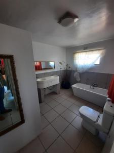 uma casa de banho com uma banheira, um WC e um lavatório. em Aviators Retreat B&B em Krugersdorp