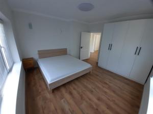 ビストリツァにあるApartament la casaのベッド1台と白いキャビネットが備わる小さな客室です。
