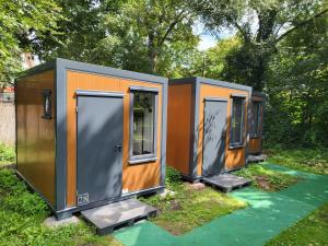 drei winzige Häuser sitzen auf dem Gras in der Unterkunft EASY Lodges Berlin in Berlin