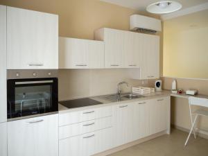 una cocina con armarios blancos y fregadero en Dino's Rooms en Lioni