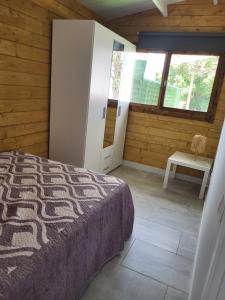 1 dormitorio con cama, mesa y ventana en Preciosa cabaña en Guía de Isora