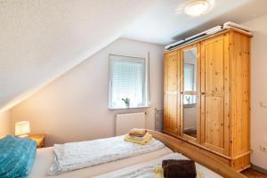 1 dormitorio con armario de madera y cama en Schwalbenhof Dreßler und Duss für 4 Personen, en Bad Herrenalb