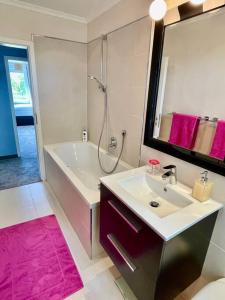 un bagno con un lavandino, una vasca e uno specchio di Exclusive Apartments Harpe a Leppin