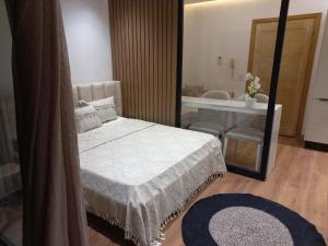een slaapkamer met een bed en een spiegel en een badkamer bij Lilia's house Al Kantaoui in Sousse
