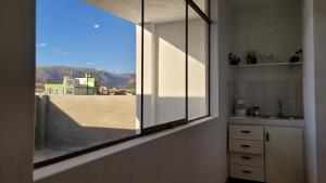 a kitchen with a window with a view of a city at Apartment with amazing view in Huancayo
