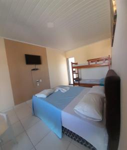 a bedroom with a blue bed and a bunk bed at Pousada Lagoa Azul in São Pedro da Aldeia