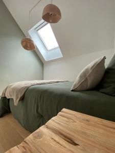 Les koumouls Grange noire في Gouesnou: غرفة نوم بسرير اخضر مع نافذة