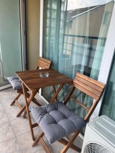 een houten tafel en 2 stoelen op een balkon bij Stivan Iskar Hotel in Sofia