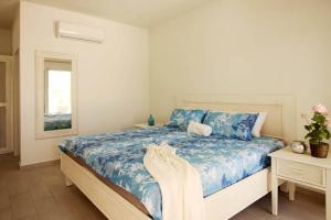 Un dormitorio con una cama con sábanas azules y blancas. en Villa Palmas Doradas, en Cabarete 21 fotos más